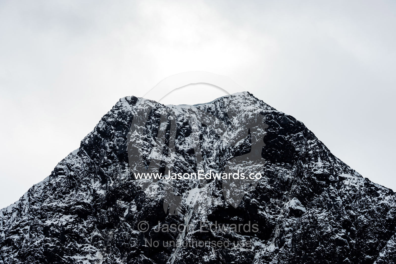 A rugged cone-shaped mountain summit dusted in snow and ice. Fjord of Eternity, Maniitsoq, Sukkertoppen, Qeqqata Municipality, Greenland.