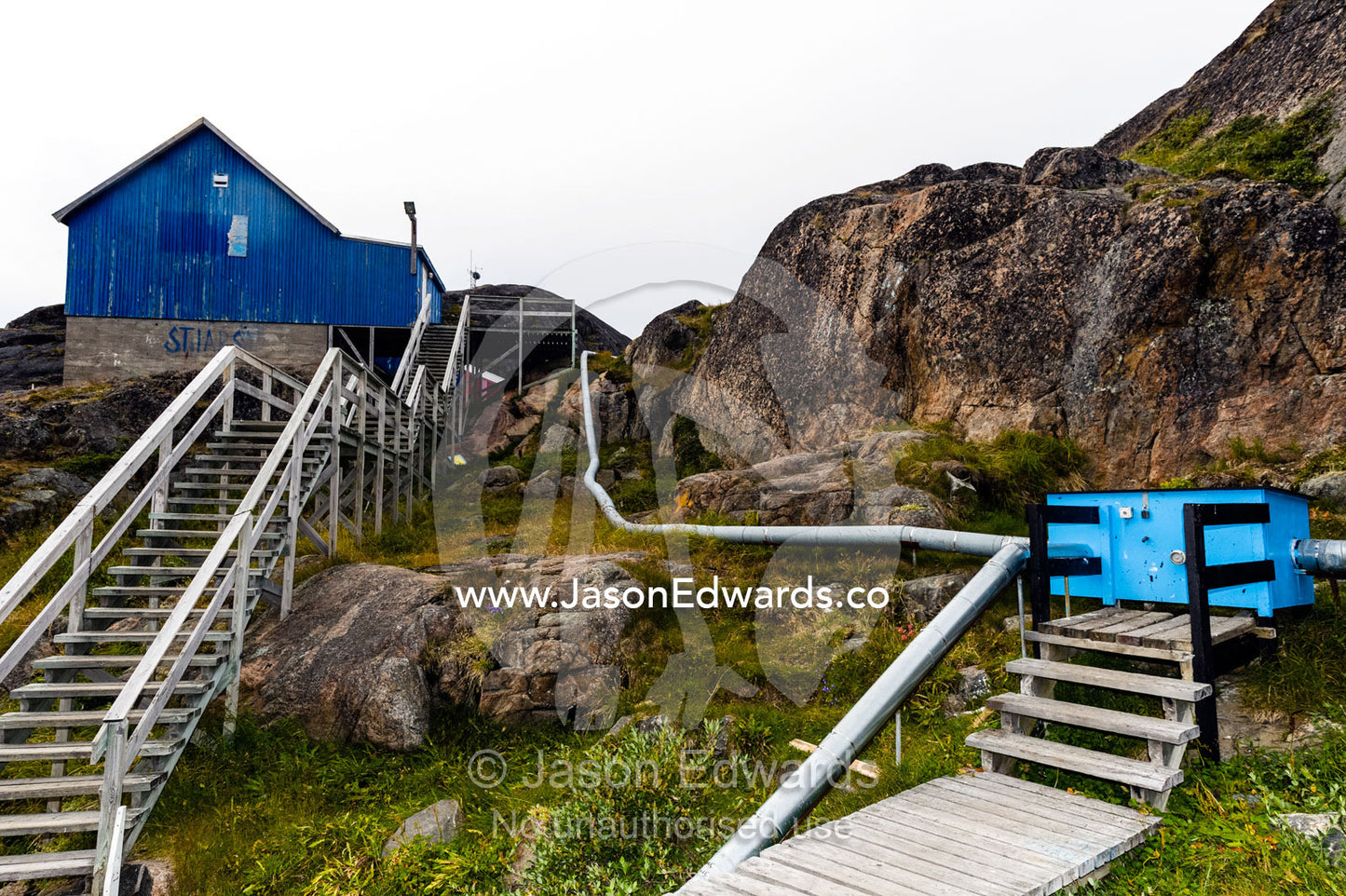 Communal steel pipes connect to homes to provide heat in an Arctic village. Kangaamiut, Gammel Sukkertoppen, Qeqqata Municipality, Greenland.
