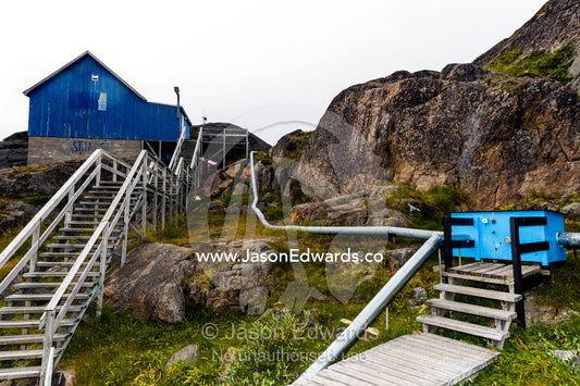 Communal steel pipes connect to homes to provide heat in an Arctic village. Kangaamiut, Gammel Sukkertoppen, Qeqqata Municipality, Greenland.
