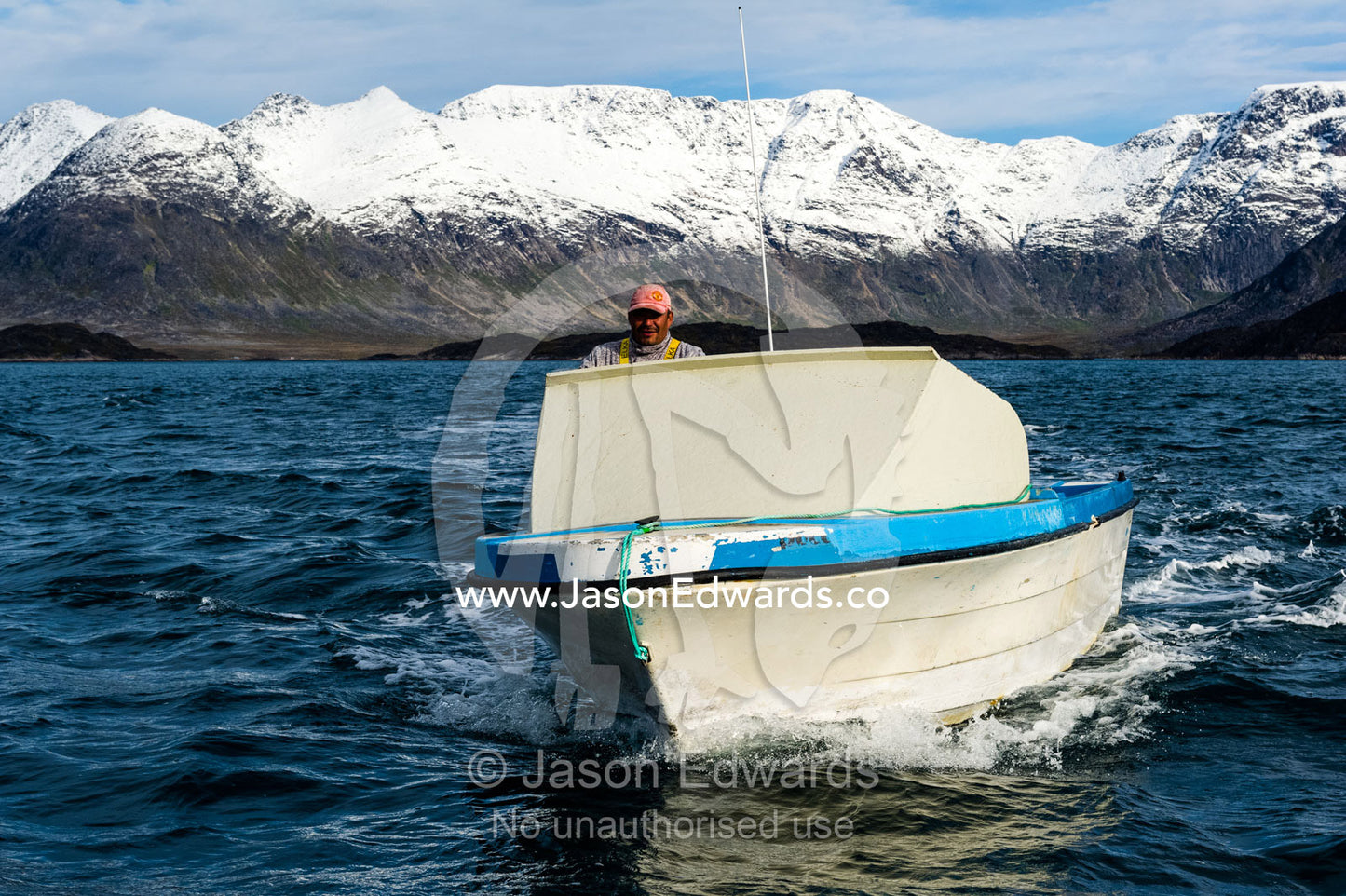 A seal hunter searches for prey in a small boat on the ocean. Davis Strait, Kangaamiut, Gammel Sukkertoppen, Qeqqata Municipality, Greenland.