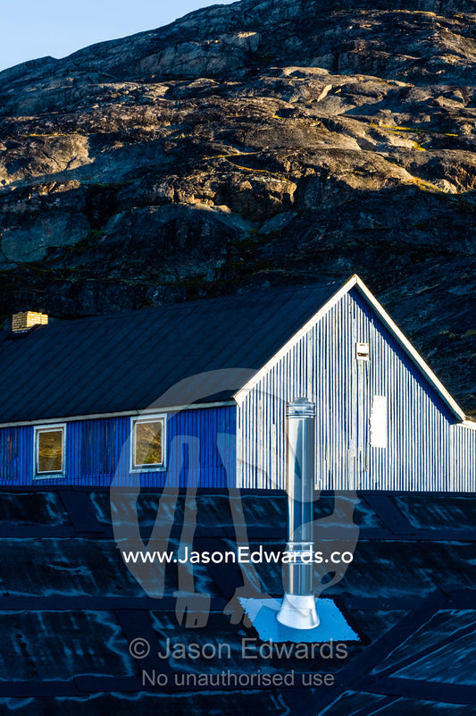 A stainless steel chimney rises from the roof of a village home. Kangaamiut, Gammel Sukkertoppen, Qeqqata Municipality, Greenland.