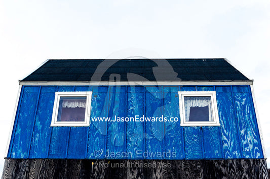 Windows in a blue fisherman's cottage in an Arctic village. Kangaamiut, Gammel Sukkertoppen, Qeqqata Municipality, Greenland.