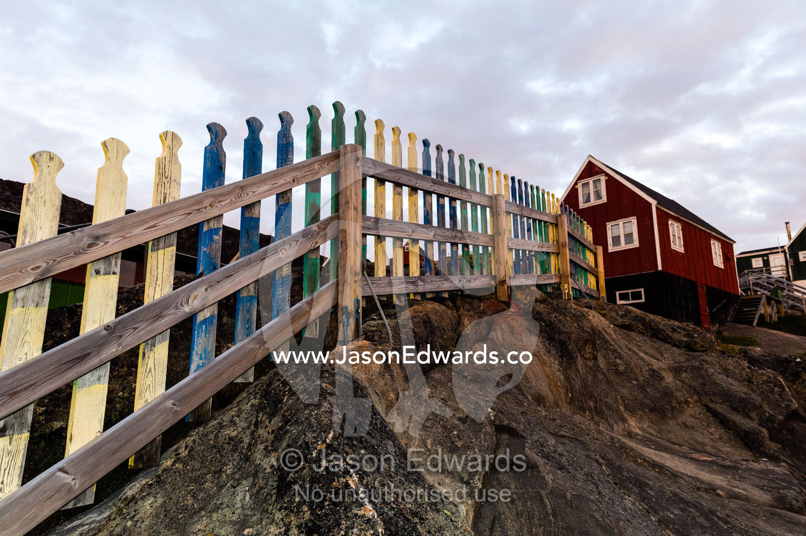 A picket fence leading to a cottage on an Arctic island. Kangaamiut, Gammel Sukkertoppen, Qeqqata Municipality, Greenland.