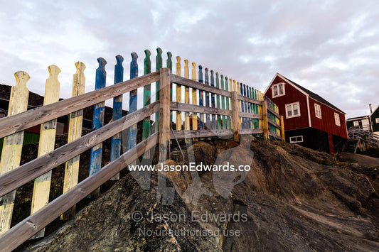 A picket fence leading to a cottage on an Arctic island. Kangaamiut, Gammel Sukkertoppen, Qeqqata Municipality, Greenland.