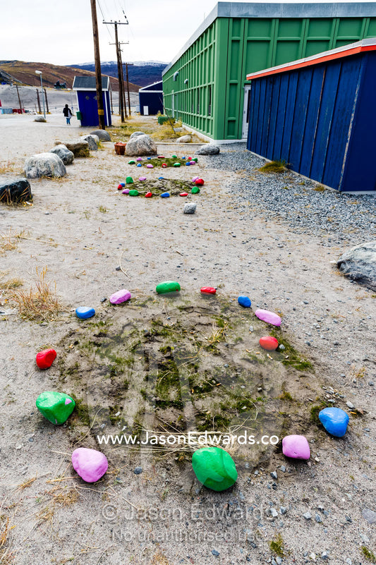 Painted rocks surround a makeshift garden bed in an arctic village adding colour to the street scene. Kangerlussuaq, Qeqqata Municipality, Greenland.