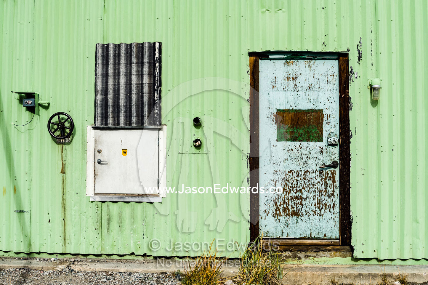 A corrugated tin wall and steel door in an old factory. Kangerlussuaq, Qeqqata Municipality, Greenland.