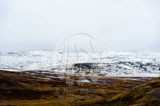 Autumn's first dusting of snow on low hills over the tundra. Greenland Ice Sheet, Qeqqata Municipality, Kangerlussuaq, Greenland.