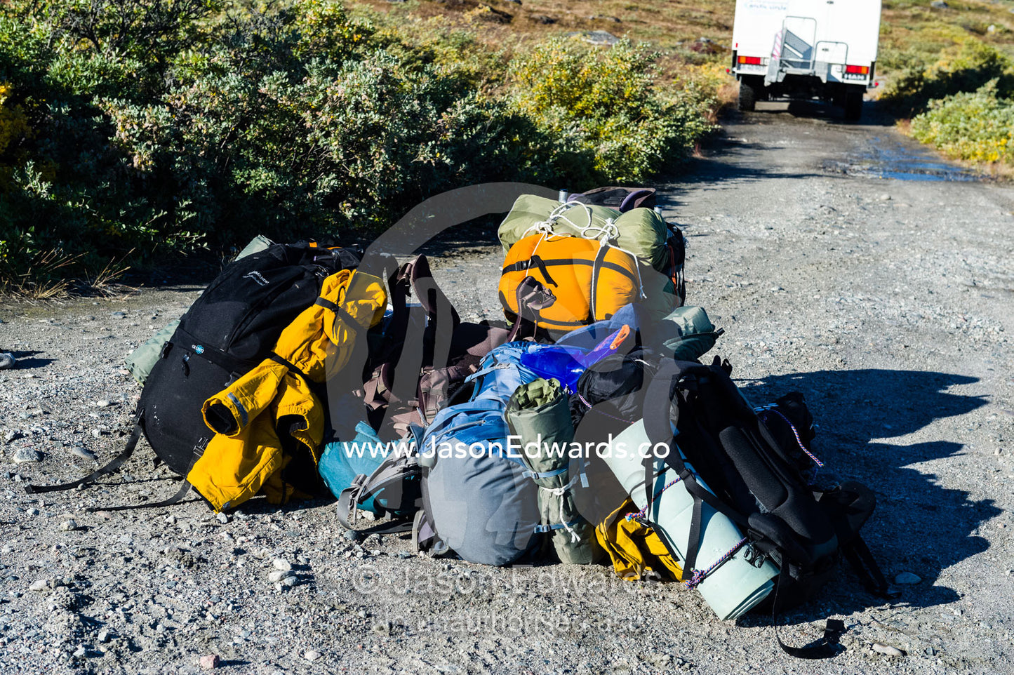 Backpacks dropped by a departing bus wait for hikers to begin their journey. Tasersuatsiaq Lake, Kangerlussuaq, Qeqqata Municipality, Greenland.