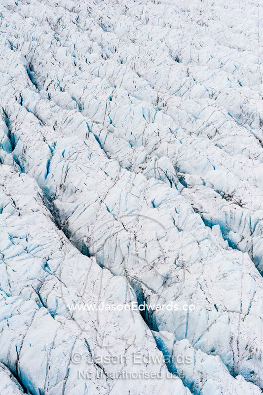 Pressure ridges and crevasse scar the surface of a glacier on the Greenland Ice Sheet. Russell Glacier, Greenland Ice Sheet, Qeqqata Municipality, Kangerlussuaq, Greenland.