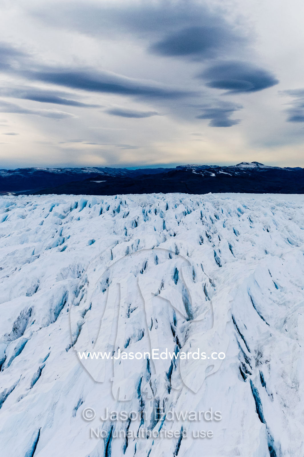 Pressure ridges and crevasse scar the surface of a glacier on the Greenland Ice Sheet. Russell Glacier, Greenland Ice Sheet, Qeqqata Municipality, Kangerlussuaq, Greenland.