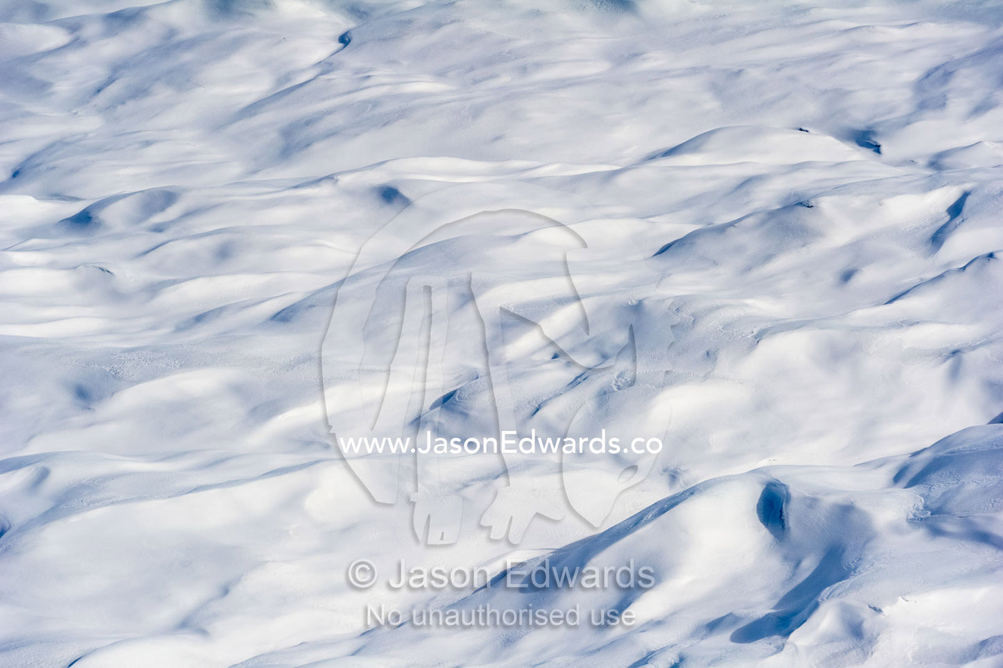 Layers of snow mask deep crevasse on the surface of the vast Greenland Ice Sheet plain. Greenland Ice Sheet, Qeqqata Municipality, Kangerlussuaq, Greenland.
