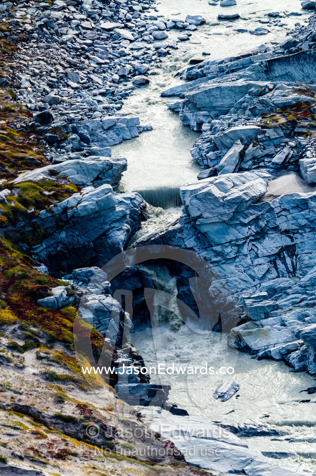 A waterfall of meltwater cascades from a glacier fracture zone. Russell Glacier, Greenland Ice Sheet, Qeqqata Municipality, Kangerlussuaq, Greenland.