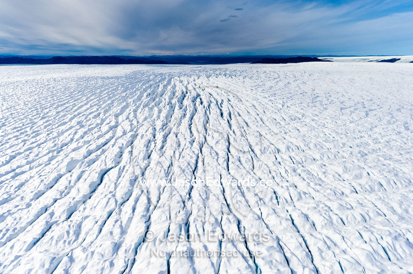 Pressure ridges and crevasse scar the surface of a glacier on the Greenland Ice Sheet. Russell Glacier, Greenland Ice Sheet, Qeqqata Municipality, Kangerlussuaq, Greenland.