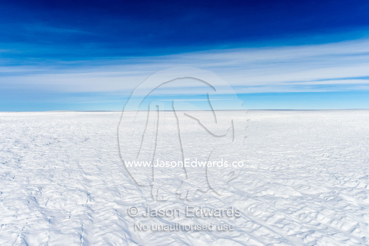 Layers of snow mask deep crevasse on the surface of the vast Greenland Ice Sheet plain. Greenland Ice Sheet, Qeqqata Municipality, Kangerlussuaq, Greenland.