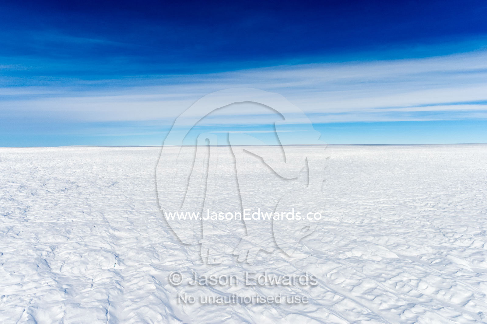 Layers of snow mask deep crevasse on the surface of the vast Greenland Ice Sheet plain. Greenland Ice Sheet, Qeqqata Municipality, Kangerlussuaq, Greenland.