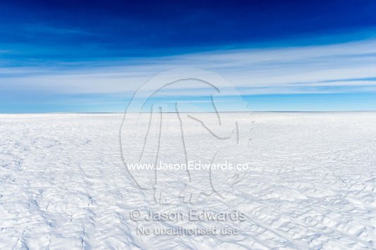 Layers of snow mask deep crevasse on the surface of the vast Greenland Ice Sheet plain. Greenland Ice Sheet, Qeqqata Municipality, Kangerlussuaq, Greenland.