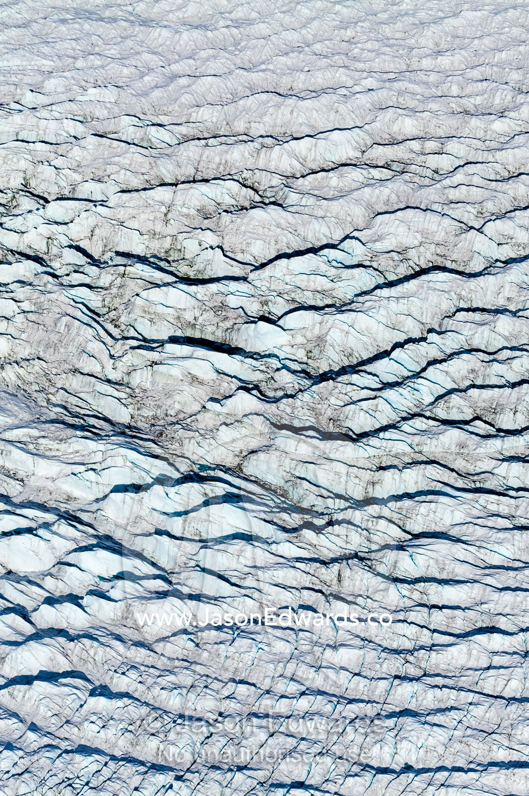 Pressure ridges and crevasse scar the surface of a glacier on the Greenland Ice Sheet. Greenland Ice Sheet, Qeqqata Municipality, Kangerlussuaq, Greenland.