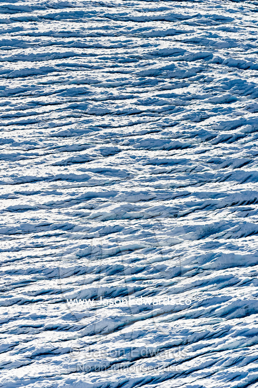 Pressure ridges and crevasse scar the surface of a glacier on the Greenland Ice Sheet. Greenland Ice Sheet, Qeqqata Municipality, Kangerlussuaq, Greenland.