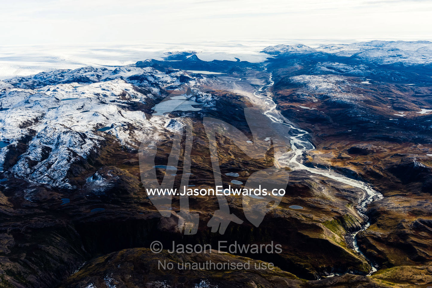 A winding river flows from a glacier and snakes it's way through a highland tundra valley. Tarajornitsut Highlands, Greenland Ice Sheet, Qeqqata Municipality, Kangerlussuaq, Greenland.