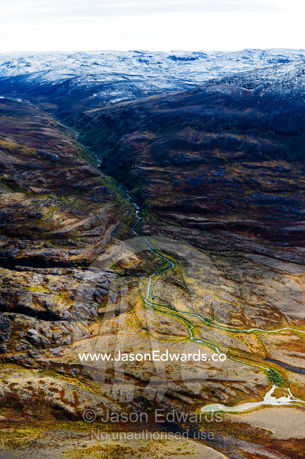 A winding river flows from a glacier and snakes it's way through a highland tundra valley. Tarajornitsut Highlands, Qeqqata Municipality, Kangerlussuaq, Greenland.
