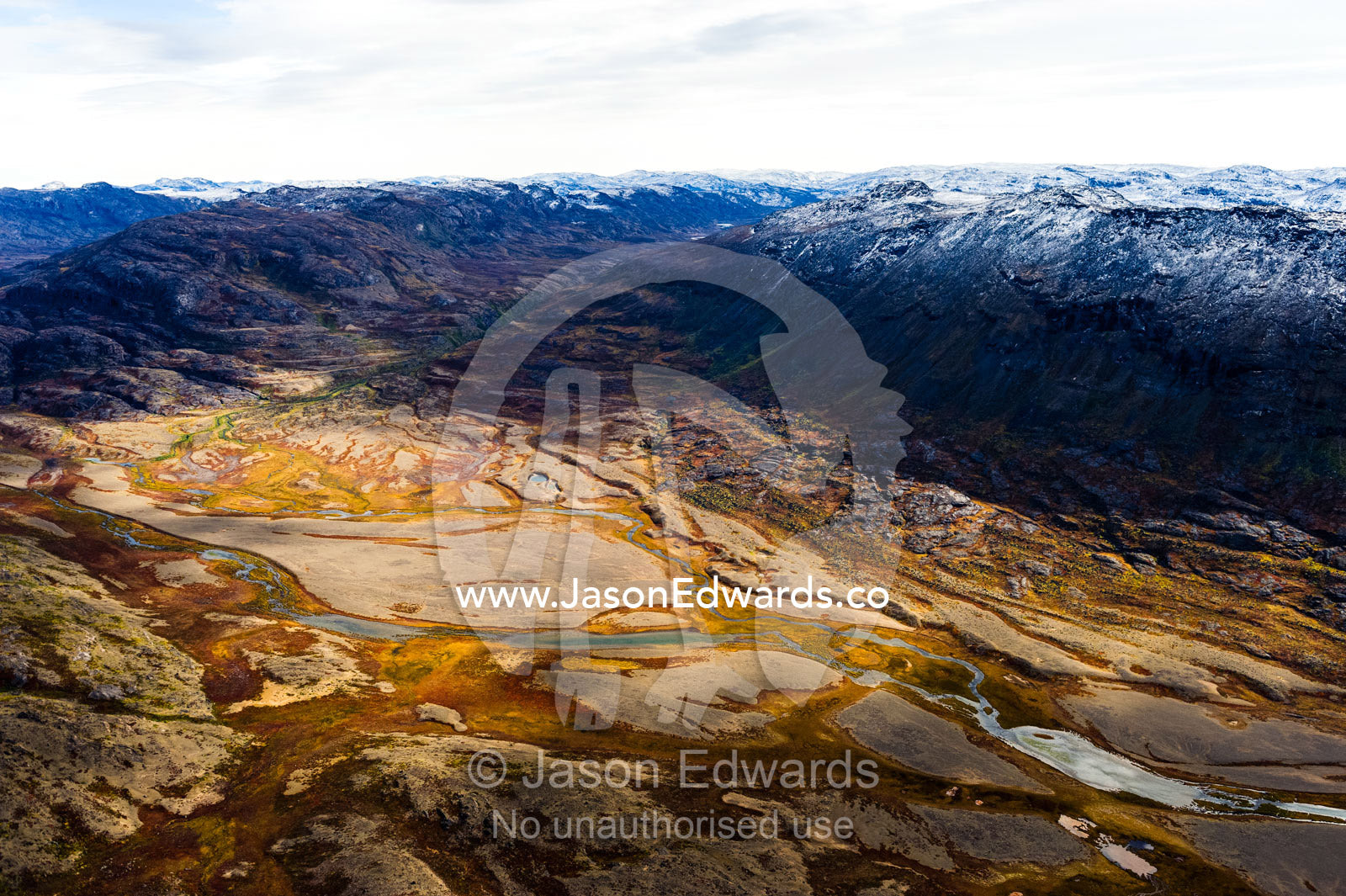 A winding river snakes it's way across a highland tundra valley floor. Tarajornitsut Highlands, Qeqqata Municipality, Kangerlussuaq, Greenland.