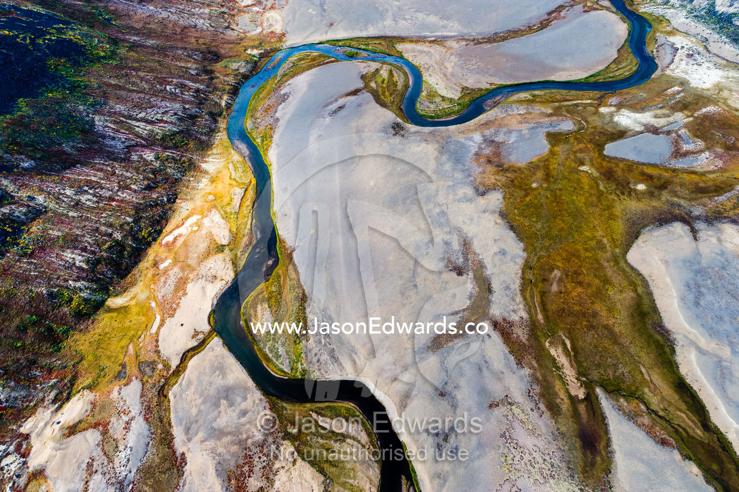 A winding river snakes it's way across a highland tundra valley floor. Tarajornitsut Highlands, Qeqqata Municipality, Kangerlussuaq, Greenland.