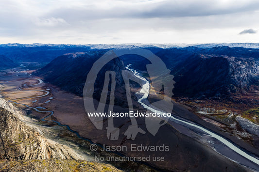 A winding river snakes it's way through a highland tundra valley to a floodplain. Tarajornitsut Highlands, Qeqqata Municipality, Kangerlussuaq, Greenland.