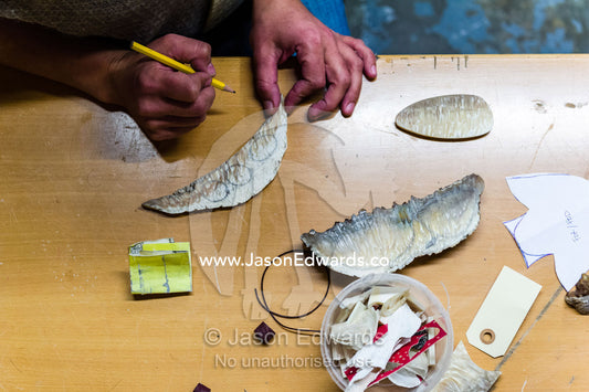 An artist carving jewelry from Musk Ox horns in her studio. Kangerlussuaq, Qeqqata Municipality, Greenland.