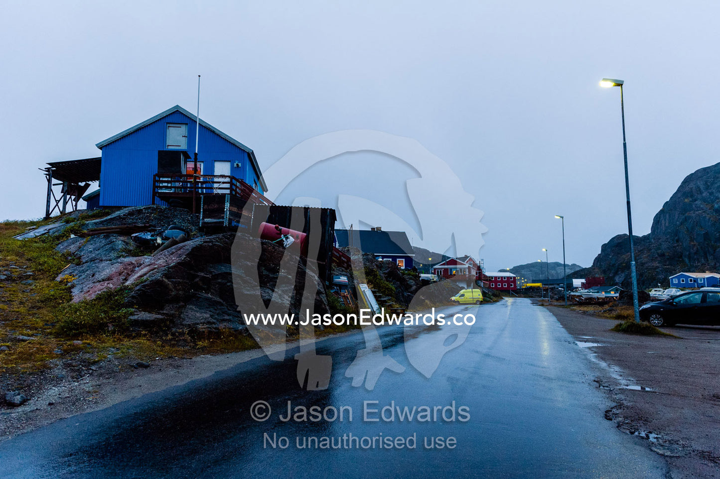 A cold and wet street at nightfall in a small fishing village. Maniitsoq, Sukkertoppen, Qeqqata Municipality, Greenland.