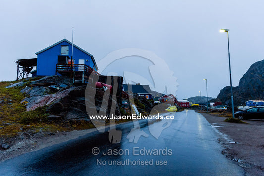 A cold and wet street at nightfall in a small fishing village. Maniitsoq, Sukkertoppen, Qeqqata Municipality, Greenland.