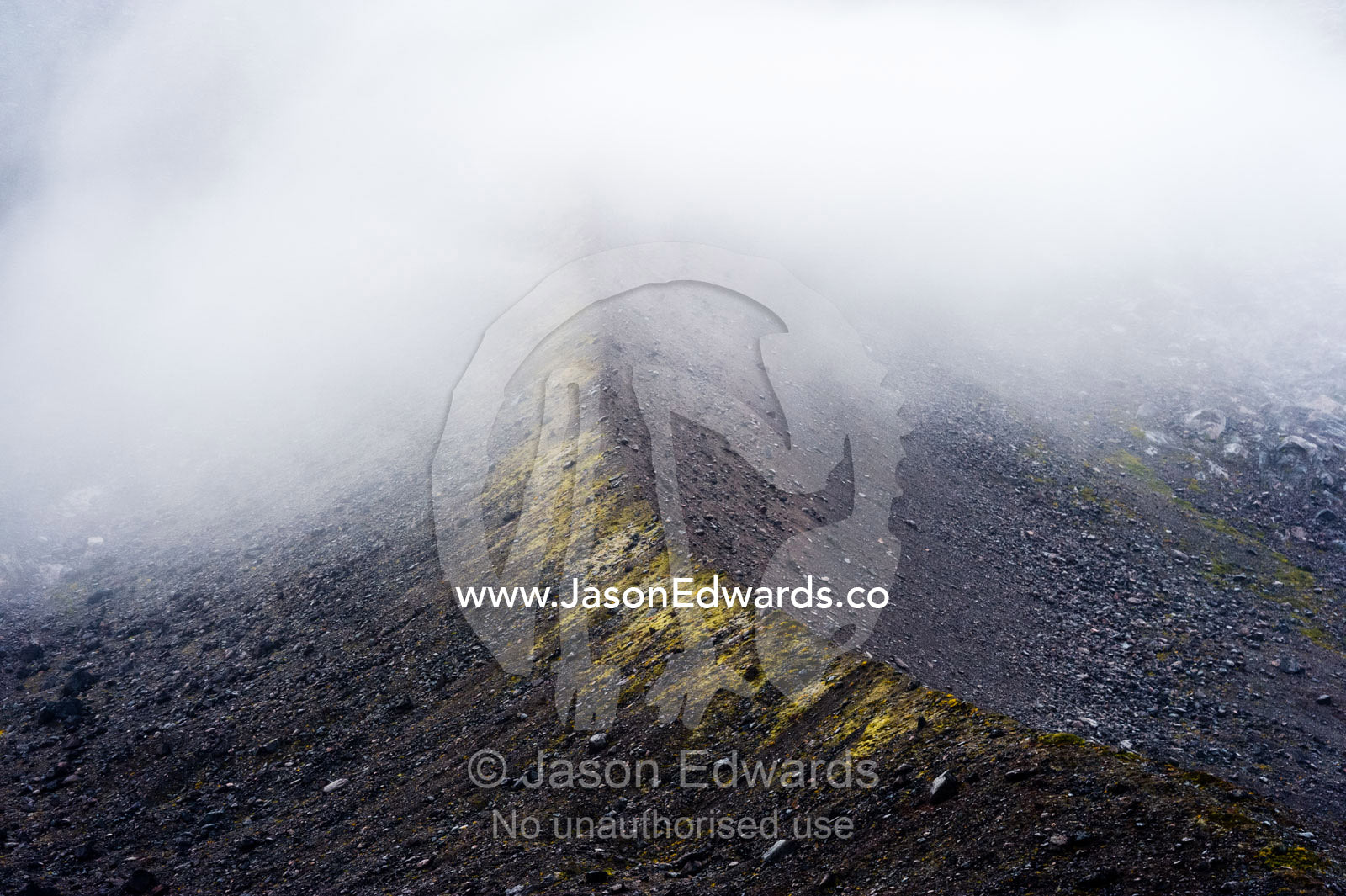 Cloud and mist shroud a mountain ridge during a rain storm in a fiord. Fjord of Eternity, Maniitsoq, Sukkertoppen, Qeqqata Municipality, Greenland.