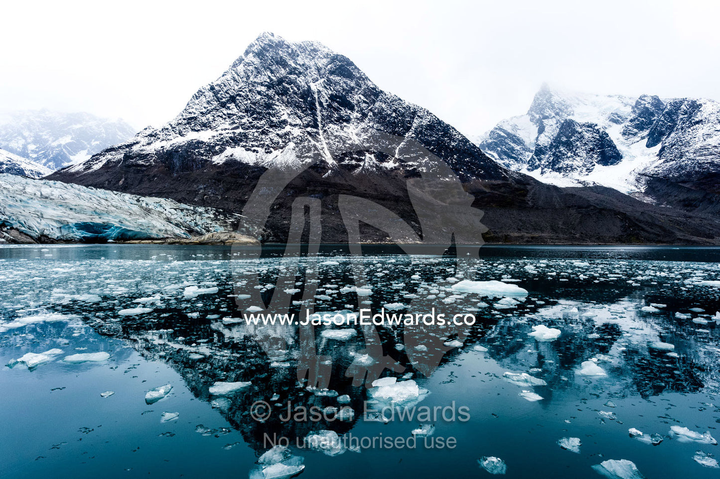 Crushed ice from a glacier carving floating on the ocean surface in a fjord. Fjord of Eternity, Maniitsoq, Sukkertoppen, Qeqqata Municipality, Greenland.