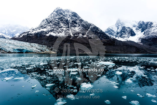 Crushed ice from a glacier carving floating on the ocean surface in a fjord. Fjord of Eternity, Maniitsoq, Sukkertoppen, Qeqqata Municipality, Greenland.