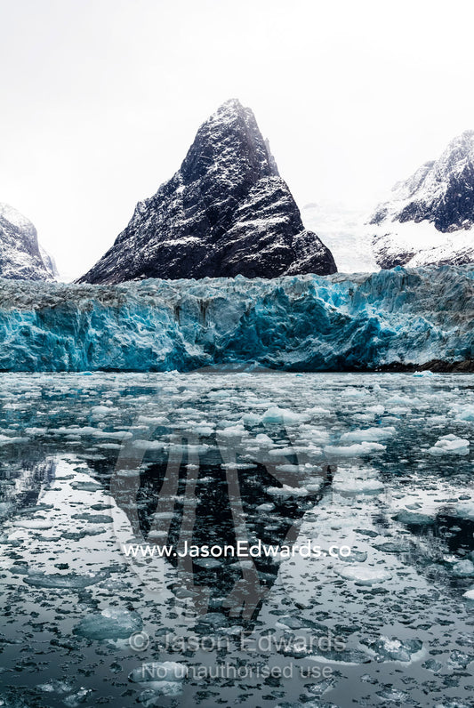 The sheer fracture zone of a glacier sandwiched between alpine peaks in a fjord. Fjord of Eternity, Maniitsoq, Sukkertoppen, Qeqqata Municipality, Greenland.