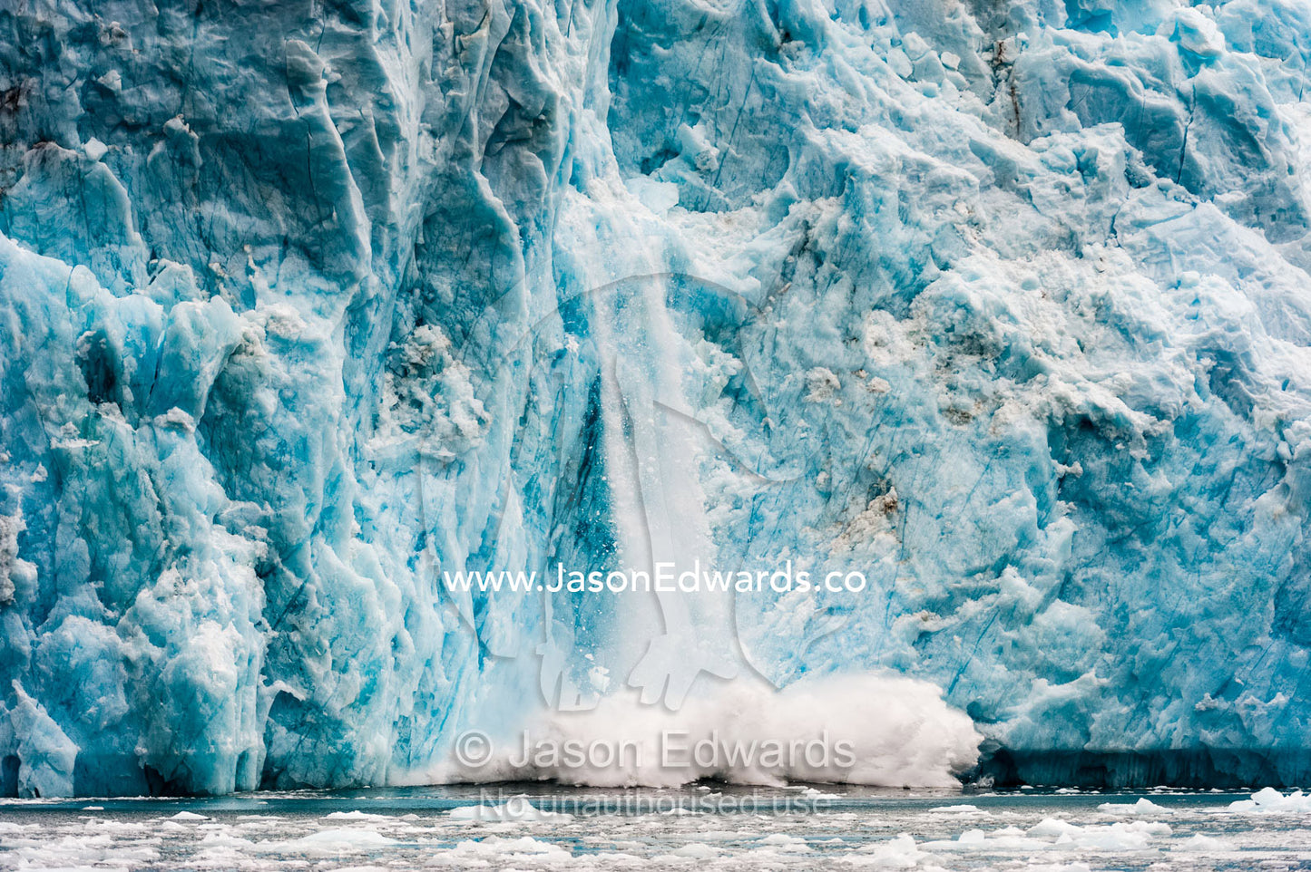 Ice calving from the fracture zone of a glacier crashing into the ocean. Fjord of Eternity, Maniitsoq, Sukkertoppen, Qeqqata Municipality, Greenland.
