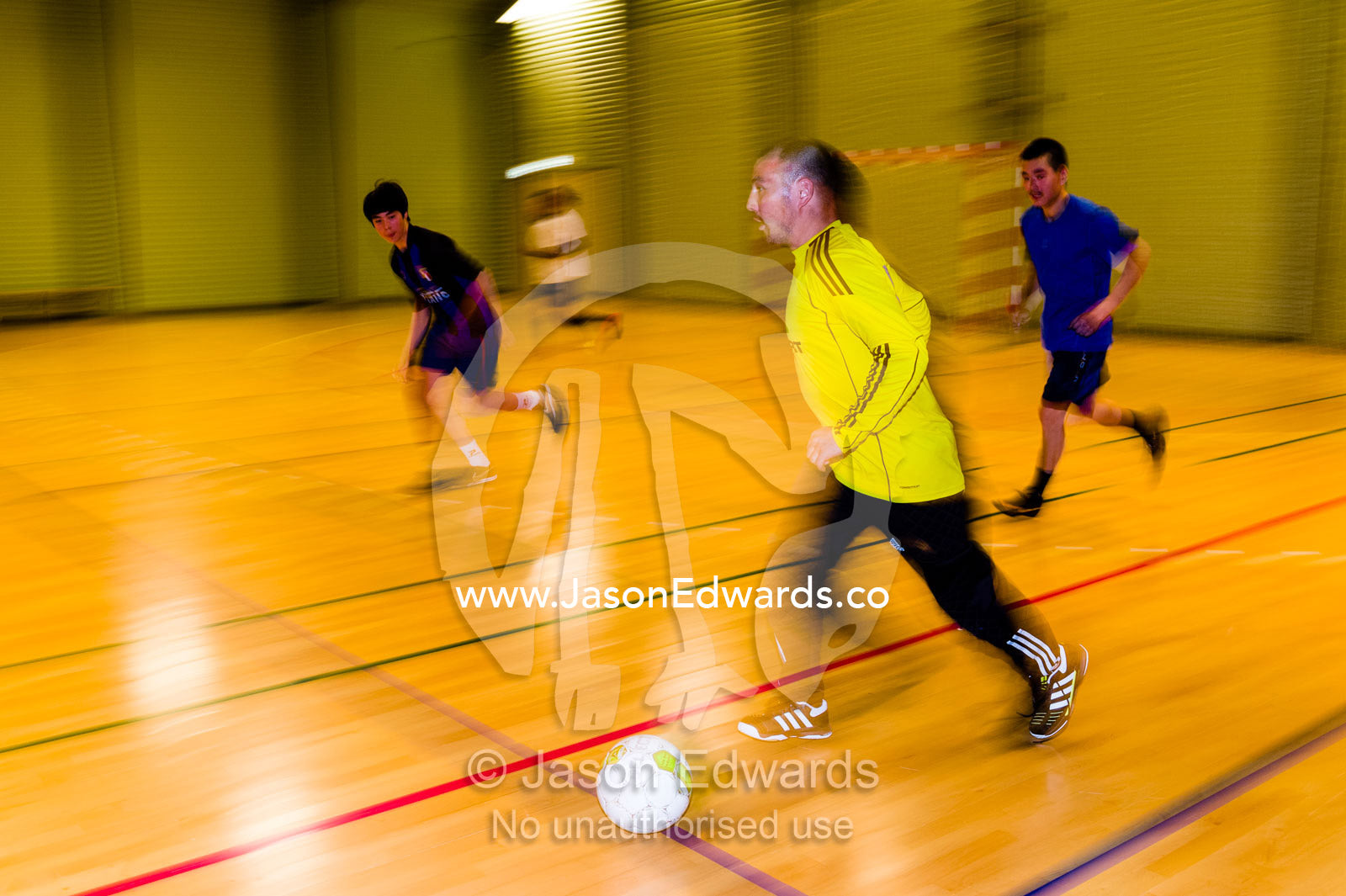Men playing a fast game of footsal in a gymnasium. Kangaamiut, Gammel Sukkertoppen, Qeqqata Municipality, Greenland.