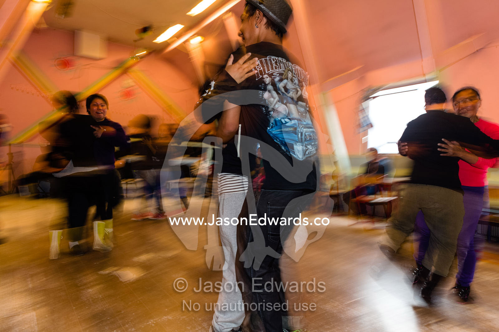 A teenage couple practicing traditional dances in a village hall. Kangaamiut, Gammel Sukkertoppen, Qeqqata Municipality, Greenland.