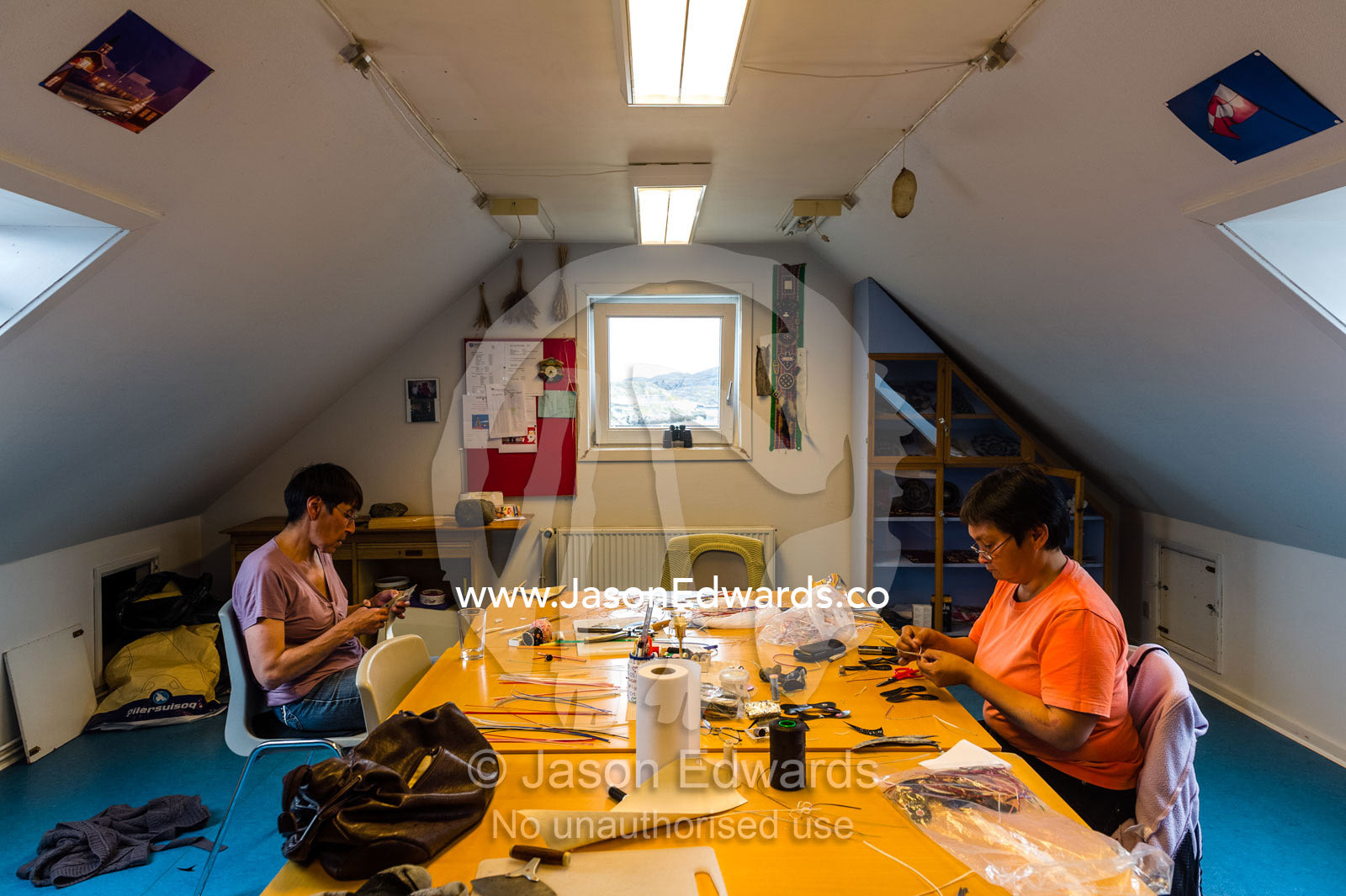 Women making souvenirs and Mukluks or Kamik a soft boot traditionally made of reindeer skin or sealskin and were originally worn by Arctic aboriginal people, including the Inuit and Yupik. Kangaamiut, Gammel Sukkertoppen, Qeqqata Municipality, Greenland.