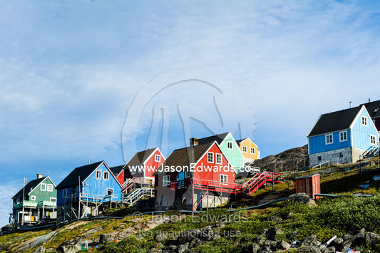 Colorful fishing houses perched on the rocky shoreline of an arctic island. Kangaamiut, Gammel Sukkertoppen, Qeqqata Municipality, Greenland.