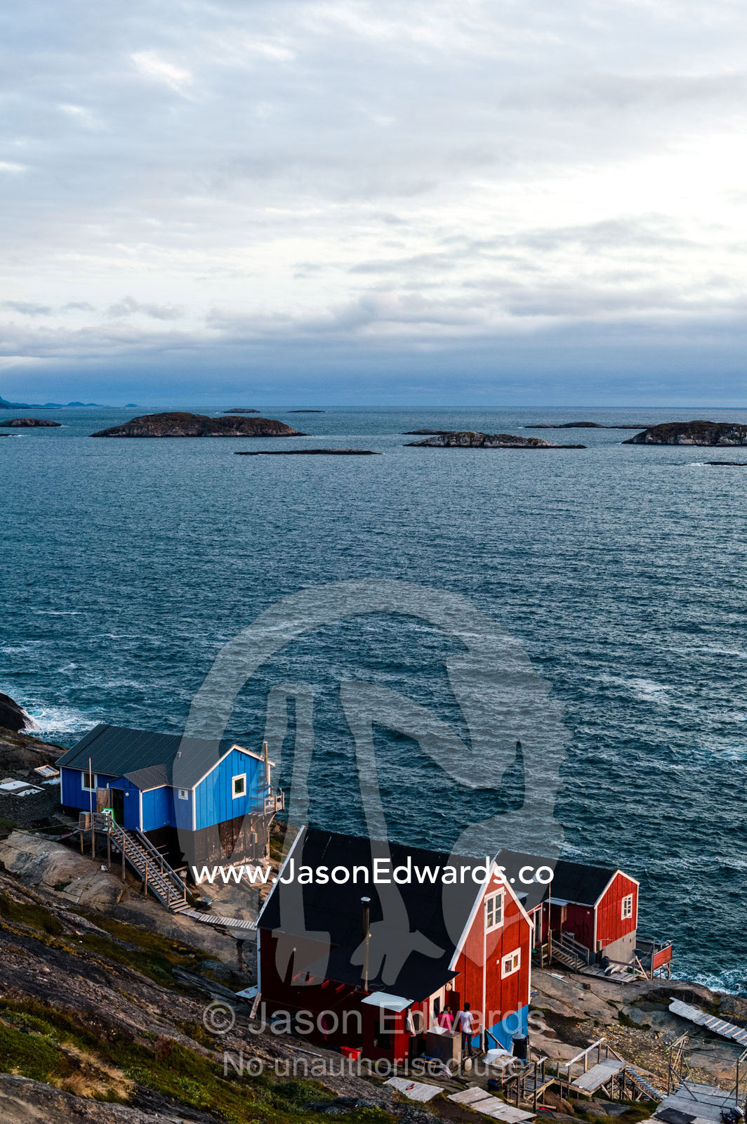 Cottages in an island fishing village overlook the ocean. Davis Strait, Kangaamiut, Gammel Sukkertoppen, Qeqqata Municipality, Greenland.