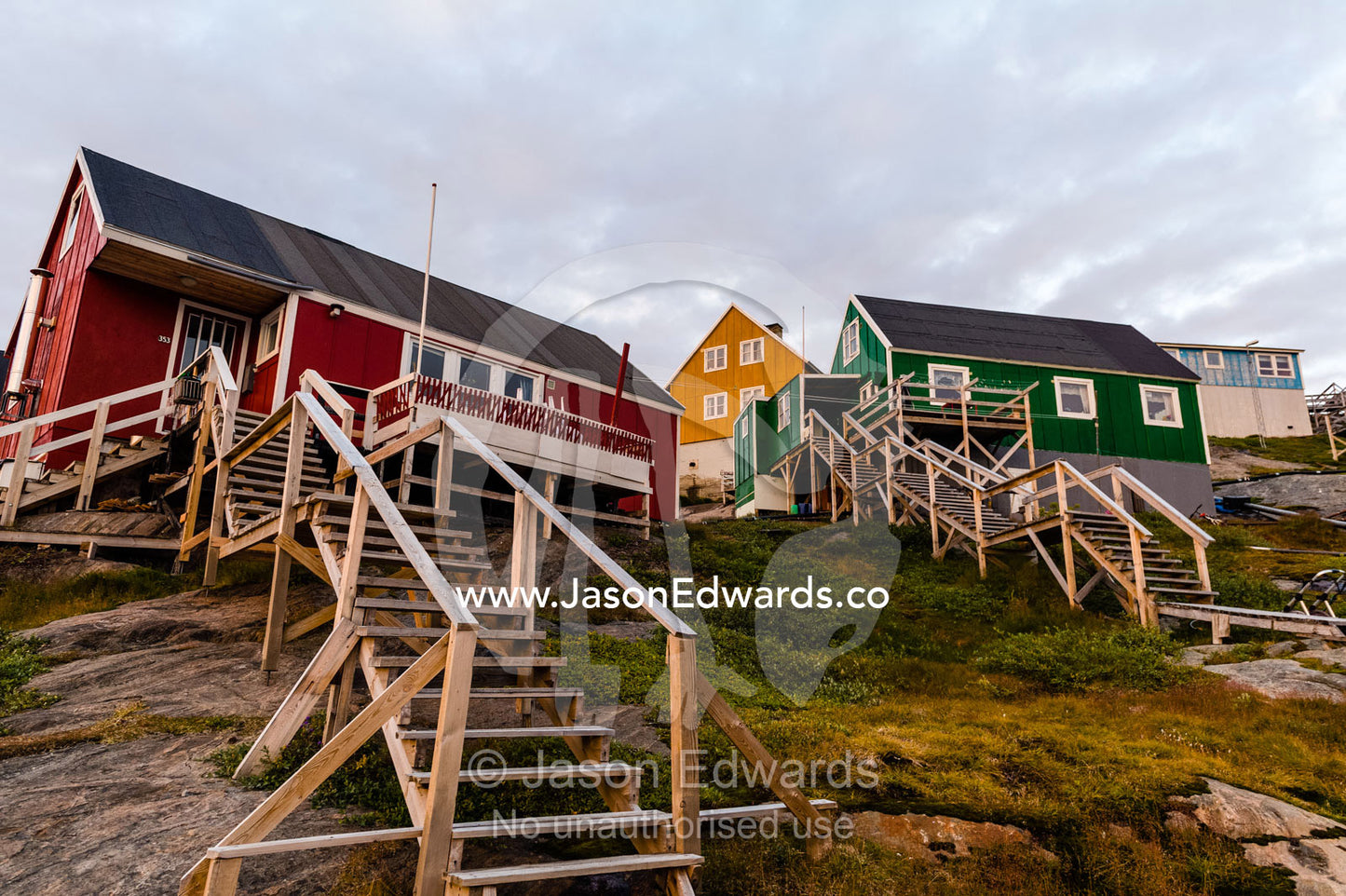 Stairs lead to cottages perched on rocky outcrops in an arctic village. Kangaamiut, Gammel Sukkertoppen, Qeqqata Municipality, Greenland.