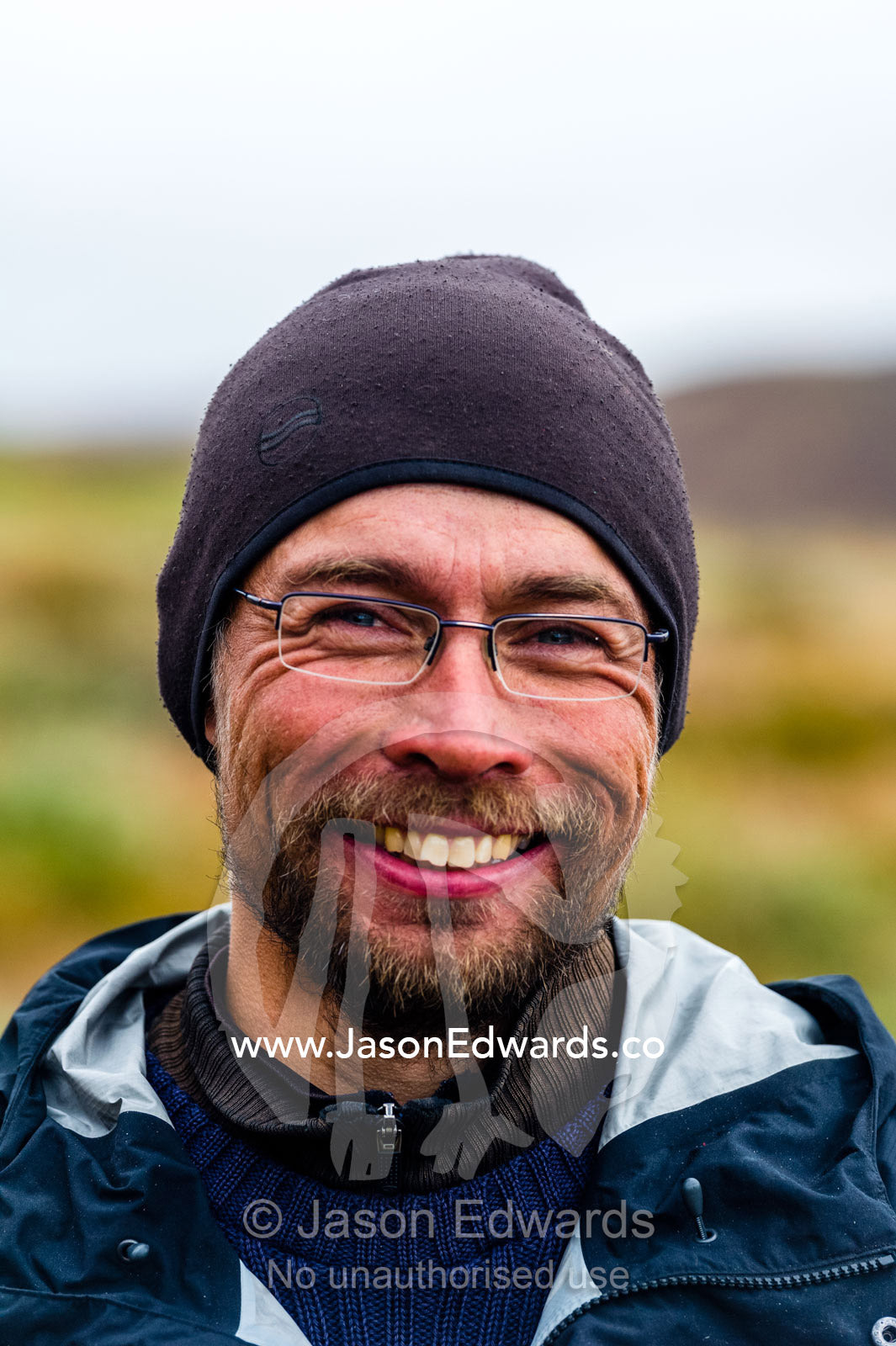 The smiling face of a Greenland guide hiking on the tundra. Ammalortup Nunaa Highland, Kangerlussuaq, Qeqqata Municipality, Greenland.