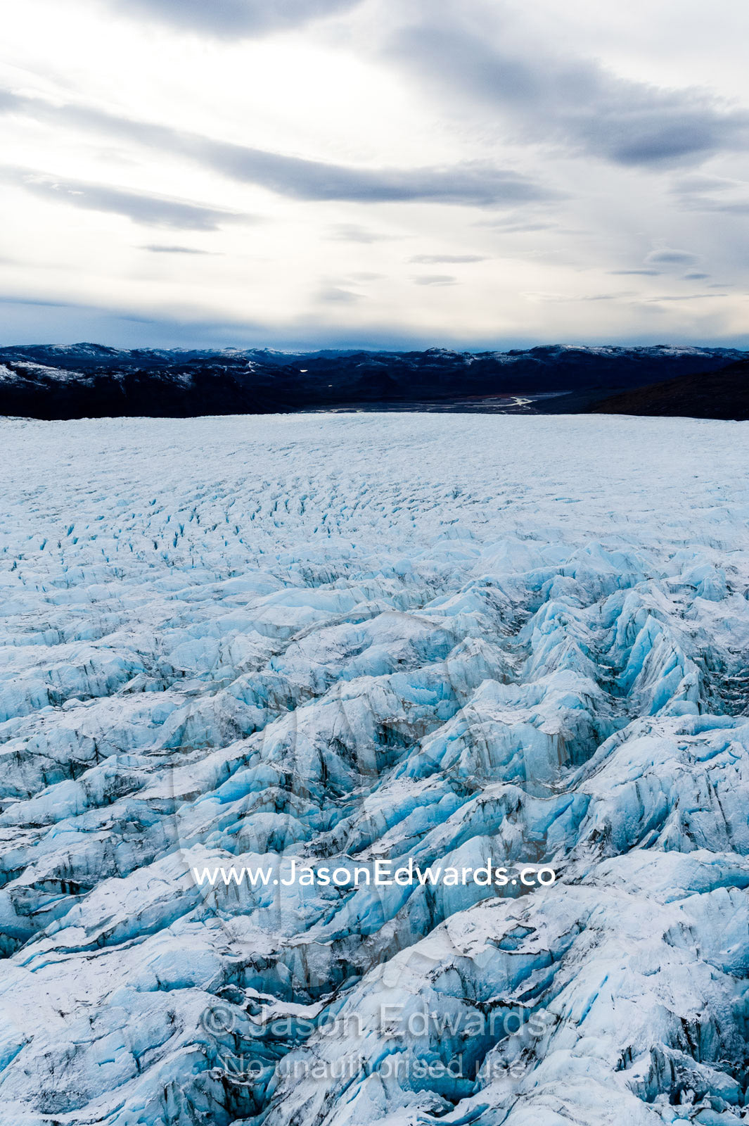 Pressure ridges and crevasse scar the surface of a glacier on the Greenland Ice Sheet. Russell Glacier, Greenland Ice Sheet, Qeqqata Municipality, Kangerlussuaq, Greenland.