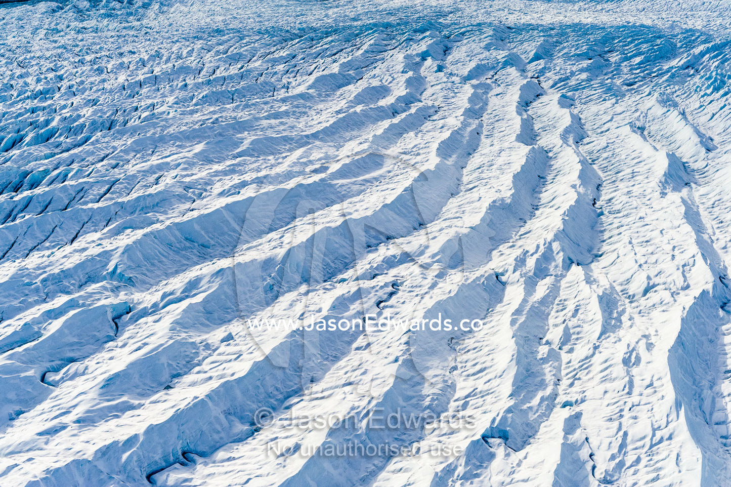 Pressure ridges and crevasse scar the surface of a glacier on the Greenland Ice Sheet. Russell Glacier, Greenland Ice Sheet, Qeqqata Municipality, Kangerlussuaq, Greenland.