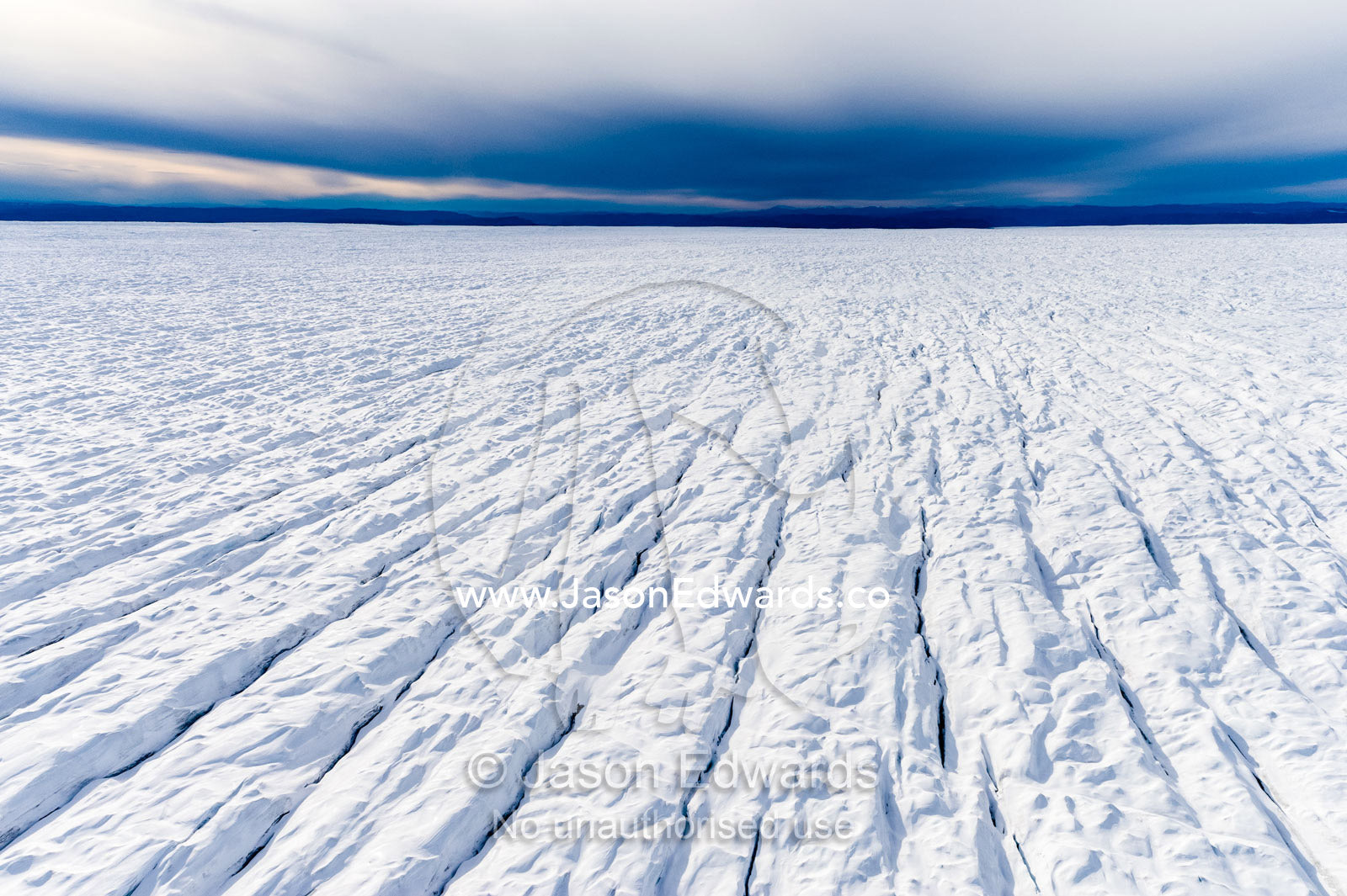 Pressure ridges and crevasse scar the surface of a glacier on the Greenland Ice Sheet. Russell Glacier, Greenland Ice Sheet, Qeqqata Municipality, Kangerlussuaq, Greenland.