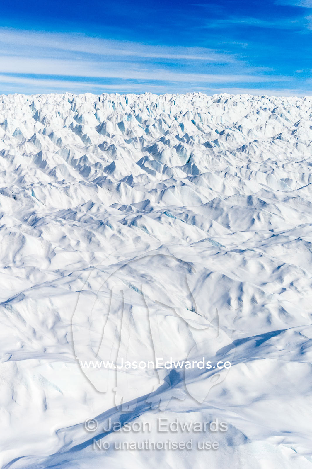 Layers of snow mask deep crevasse on the surface of the vast Greenland Ice Sheet plain. Greenland Ice Sheet, Qeqqata Municipality, Kangerlussuaq, Greenland.
