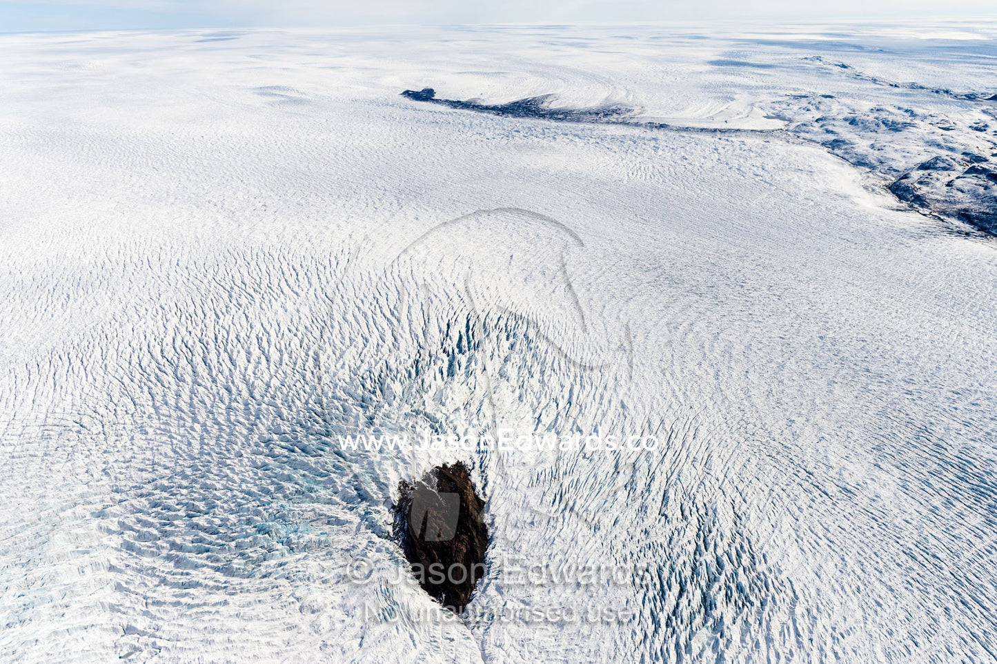 Pressure ridges in a glacier build up around an island in the Greenland Ice Sheet. Greenland Ice Sheet, Qeqqata Municipality, Kangerlussuaq, Greenland.