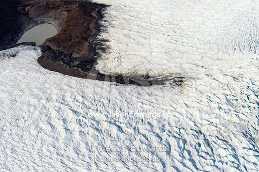 Pressure ridges in a glacier build up around an island in the Greenland Ice Sheet. Greenland Ice Sheet, Qeqqata Municipality, Kangerlussuaq, Greenland.