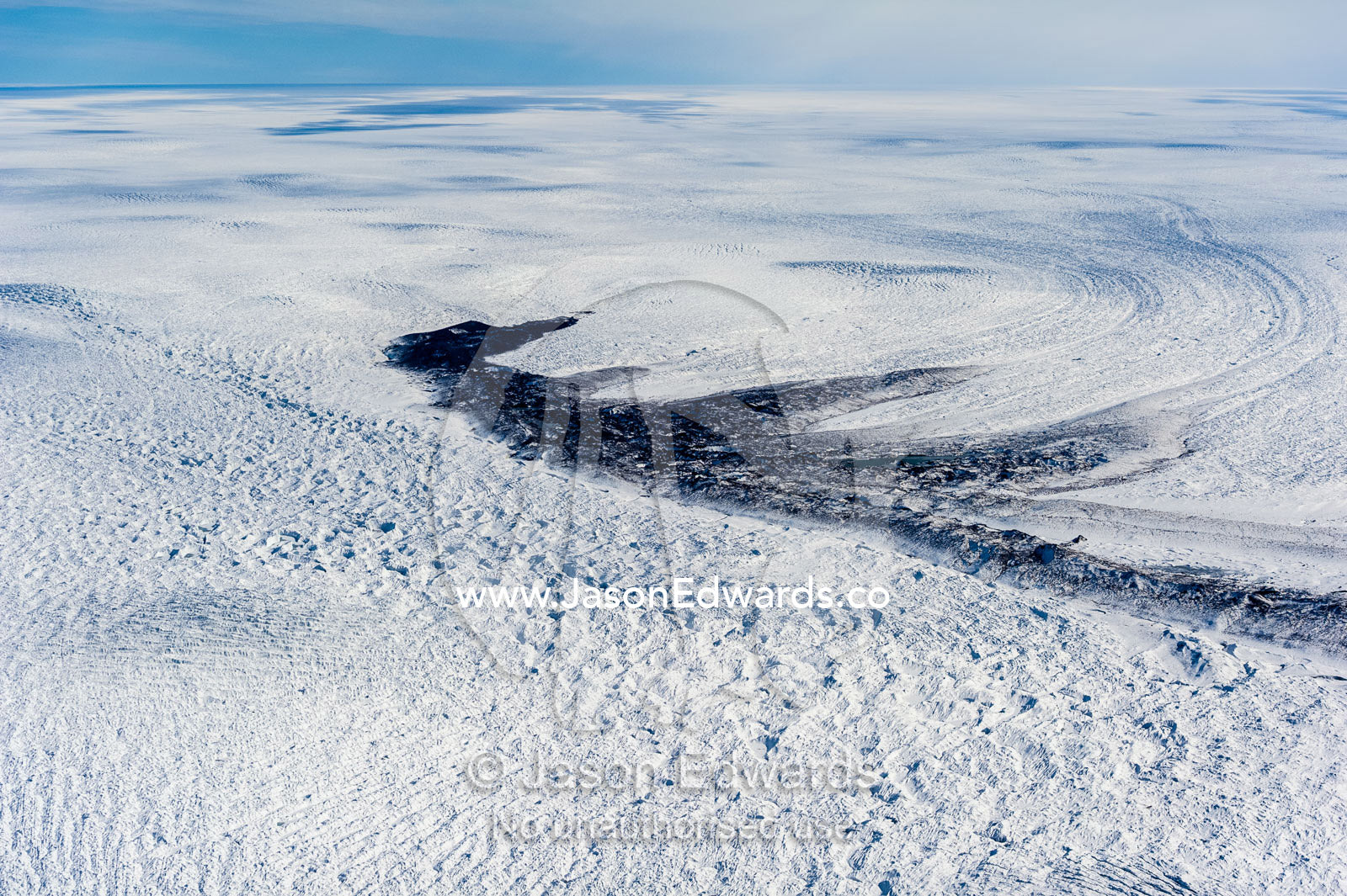 A melt pond on the surface of the Greenland Ice Shelf. Greenland Ice Sheet, Qeqqata Municipality, Kangerlussuaq, Greenland.