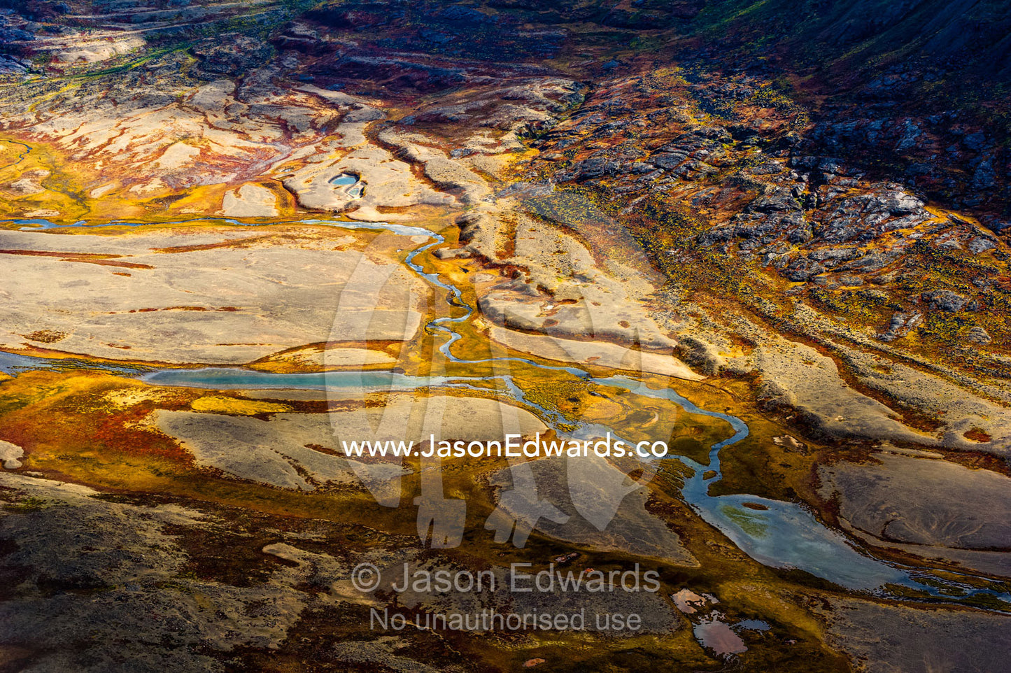 A winding river snakes its way across a highland tundra valley floor. Tarajornitsut Highlands, Qeqqata Municipality, Kangerlussuaq, Greenland.